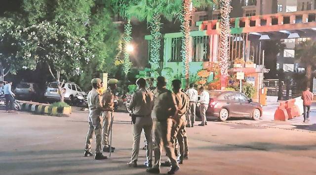 Police at the society after the men barged in. (Express Photo)