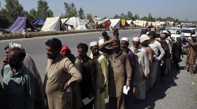 Flood-affected people line up to receive food in Pakistan’s Charsadda, Monday. (AP)
