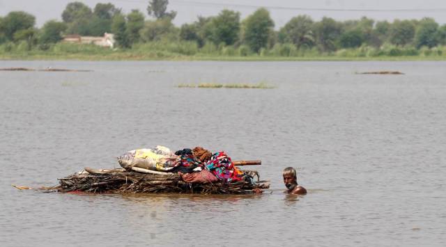 A displaced man transports usable belongings salvaged from his flood-hit home across a flooded area in the Shikarpur district of Sindh province, Pakistan. (AP/file)