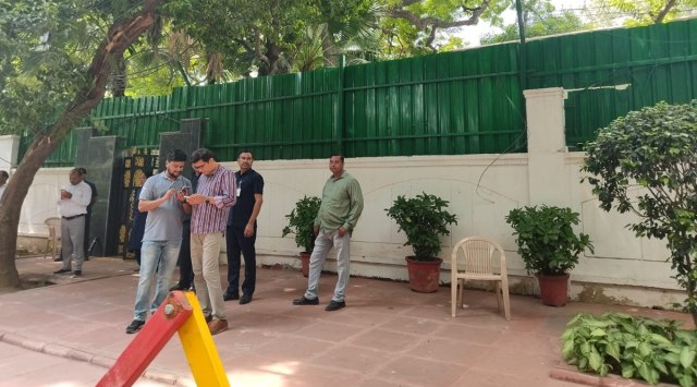 AAP national spokesperson Saurabh Bharadwaj waits outside Delhi CM Arvind Kejriwal's residence to keep count of MLAs as they arrive, in New Delhi on Thursday. (Express Photo)
