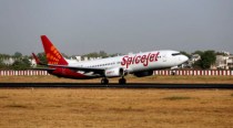 SpiceJet flyers walk on airport's tarmac after waiting for bus