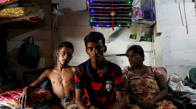 Gamage Rupawathi (R), 60, her husband W. A. Susantha (C), 45, and their son, Krishan Darshana (L), 25, pose at their home, amid the country's economic crisis, in Colombo, Sri Lanka, August 2, 2022. (Reuters)