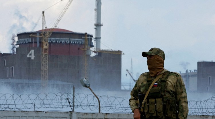 A serviceman with a Russian flag on his uniform stands guard near the Zaporizhzhia Nuclear Power Plant in the course of Ukraine-Russia conflict outside the Russian-controlled city of Enerhodar in the Zaporizhzhia region, Ukraine August 4, 2022. (Reuters)