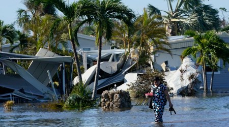 Holly Nugyn walks out of her flooded neighborhood after Hurricane Ian passed by the area Thursday, Sept. 29, 2022, in Fort Myers, Fla. (AP)