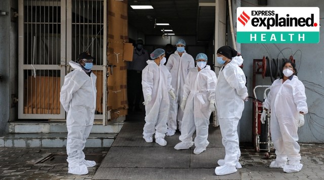 Healthcare staff wait to receive patients at the entrance of Covid-19 ward at Civil hospital, Asarwa in July 2021. (Express Photo: Nirmal Harindran, File)