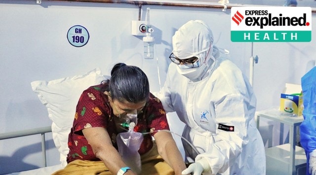 Doctors help a Covid-19 patient at a Covid care ward in Ahmedabad. (Express Photo: Nirmal Harindran, File) 