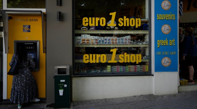 A woman uses an ATM machine in the main town of the Aegean Sea island of Rhodes, southeastern Greece, Tuesday, May 10, 2022. (AP/File)