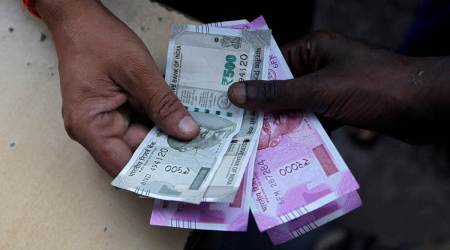 A customer hands Indian currency notes to an attendant at a fuel station in Mumbai, India, August 13, 2018. (REUTERS/File Photo)