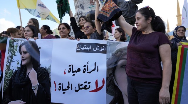 Kurdish women activists hold headscarfs and a portrait of Iranian woman Mahsa Amini, with Arabic that reads, "The woman is life, don't kill the life," during a protest against her death in Iran, at Martyrs' Square in downtown Beirut, Wednesday, Sept. 21, 2022. (AP)