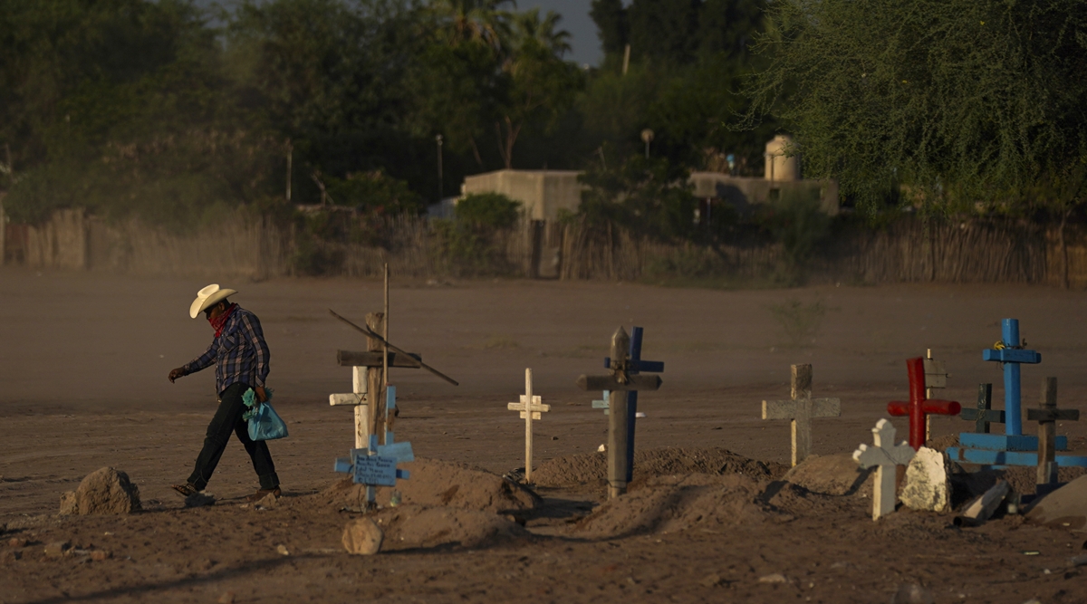 A Yaqui Indigenous wears a bandana over his mouth as he walks through dust past the cemetery where slain water-defense leader Tomás Rojo is buried in Potam, Mexico, Tuesday, Sept. 27, 2022. Rojo was a descendent of Tetabiate, a Yaqui leader killed in a 1901 battle with the government, which deported the surviving Yaquis to work in slave-like conditions on henequen plantations in far-away Yucatan. (AP)