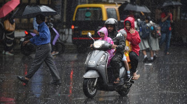 Commuters use umbrellas and raincoats to shield themselves as they move on a road amid rainfall, in Mumbai, Tuesday, Sept. 20, 2022. (PTI Photo/file)