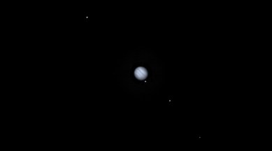 Image of jupiter and four moons captured by NASA's DART