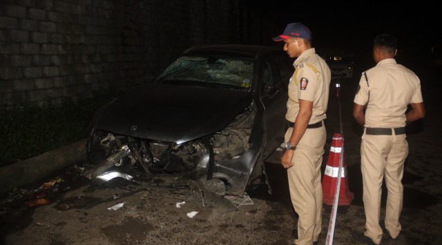 Police men inspect the car after the crash. (Express Photo)