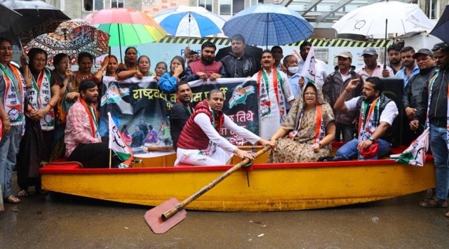 The pune unit of NCP staged a symbolic protest by acting to row a boat outside the PMC office in Pune on Tuesday. (Express Photo by Oshwin Kadhao) 