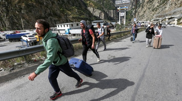 Travellers walk after crossing the border with Russia at the frontier checkpoint Verkhny Lars - Zemo Larsi, Georgia September 28, 2022. (REUTERS/Irakli Gedenidze) 