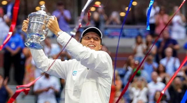 Iga Swiatek, of Poland, holds up the championship trophy after defeating Ons Jabeur, of Tunisia, to win the women's singles final of the U.S. Open tennis championships, Saturday, Sept. 10, 2022, in New York. (AP Photo/Frank Franklin II)