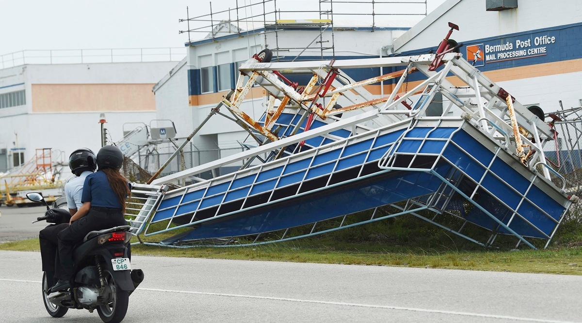 A motorcyclist rides past a catamaran turned on its side in the aftermath of Hurricane Fiona, in St. George, Bermuda, Sept. 23, 2022. (AP)