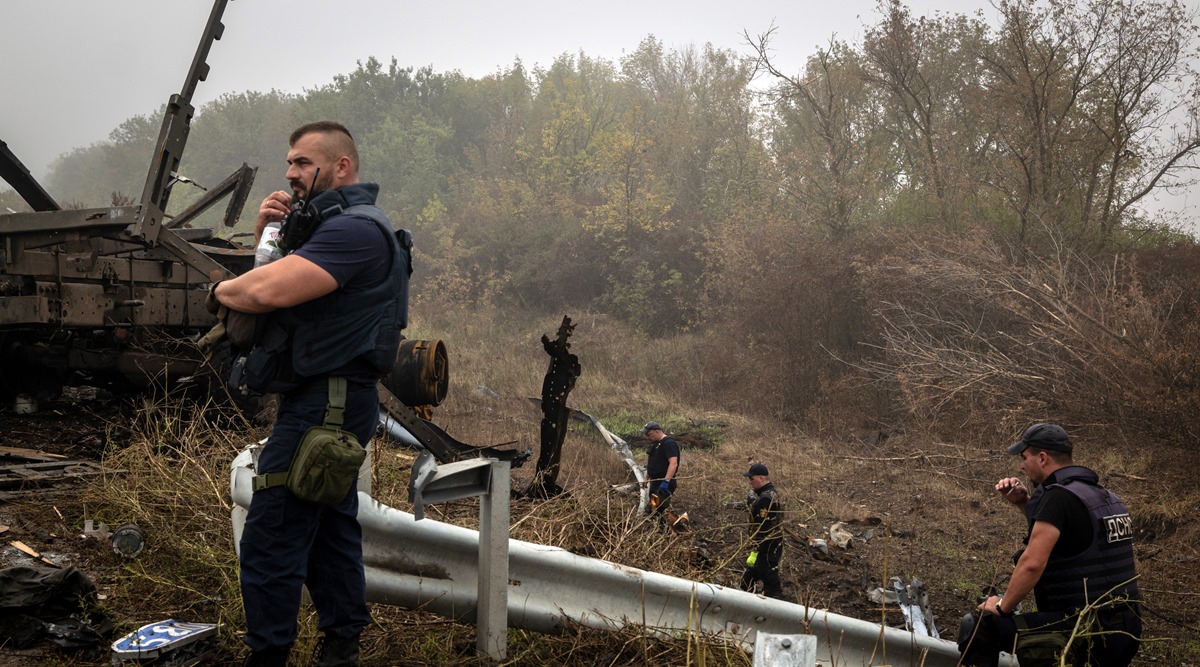 Ukrainian emergency services workers collect unexploded ordnance from the side of the road near Izium, Ukraine (NYT photo)
