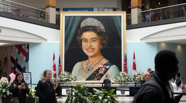 Shoppers walk past a five-meter-high image of Queen Elizabeth II, painted by billboard artist Gilbert Burch in 1979, at CF Polo Park in Winnipeg, Manitoba, Canada on September 17, 2022. (REUTERS/Shannon VanRaes)