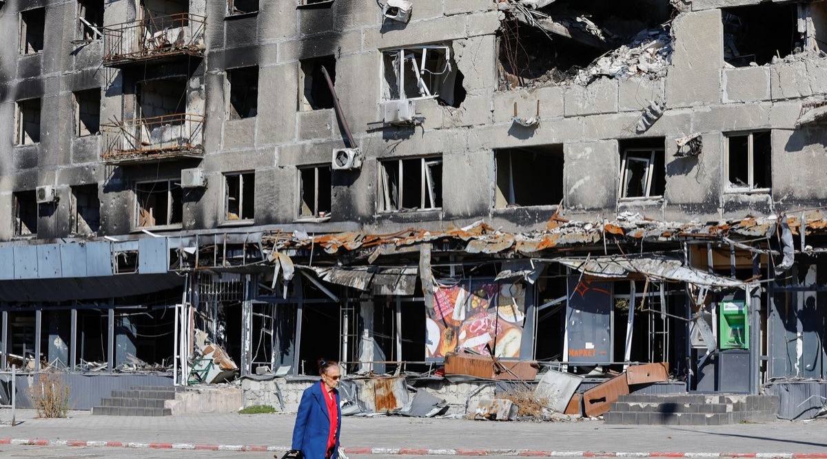 A local resident walks past an apartment block damaged in the course of Russia-Ukraine conflict in Mariupol, Ukraine. (REUTERS/Alexander Ermochenko)