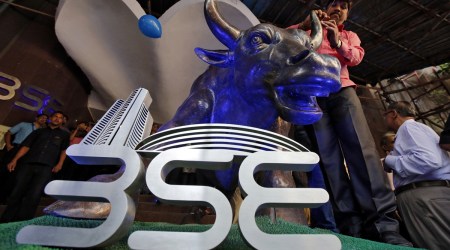 A man ties a balloon to the horns of a bull statue at the entrance of the Bombay Stock Exchange (BSE). (Reuters/File)