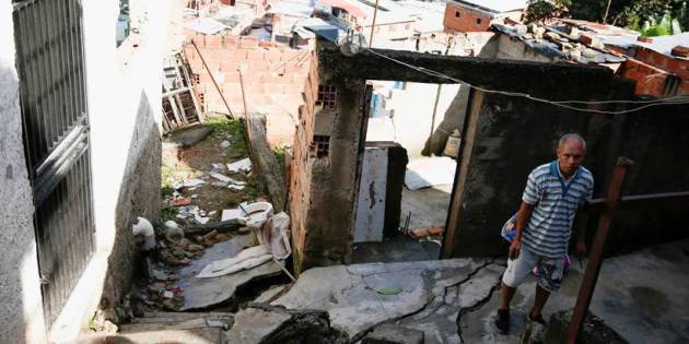 house damaged, people wait for evacuation