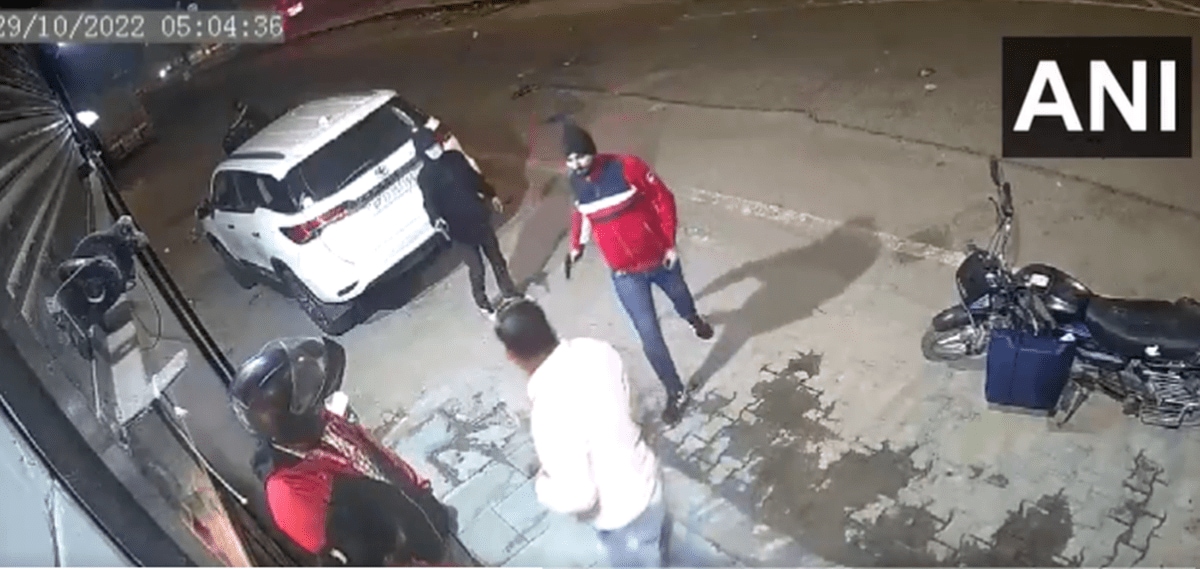 Men in red and black can be seen brandishing gun  and white SUV parked behind them (Screengrab of video shared by news agency ANI) 