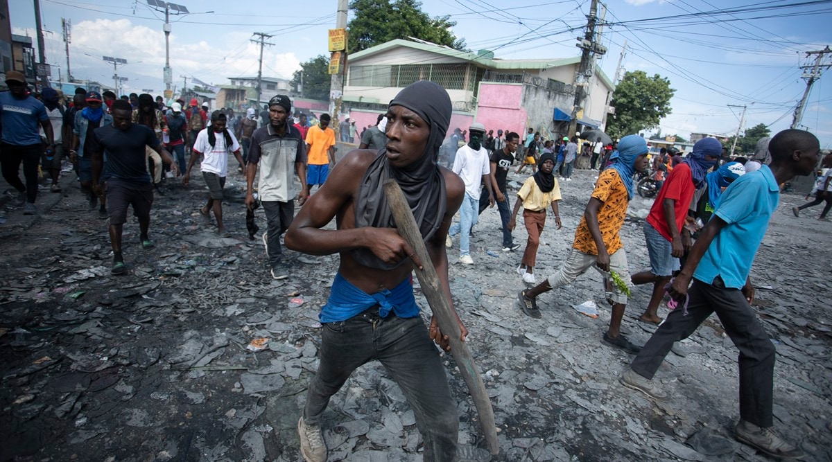 A protester carries a piece of wood simulating a weapon during a protest demanding the resignation of Prime Minister Ariel Henry, in the Petion-Ville area of Port-au-Prince, Haiti, Oct. 3 (AP photo)