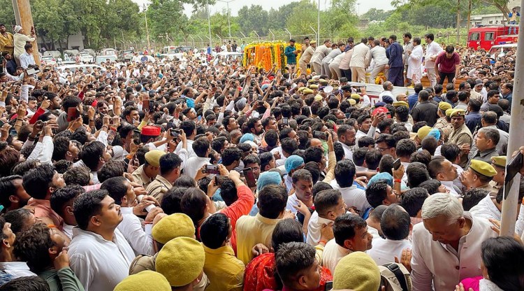 People gather to pay tribute to the mortal remains of Samajwadi Party founder Mulayam Singh Yadav, at his native village Saifai in Etawah district, Tuesday, Oct. 11, 2022. (PTI)
