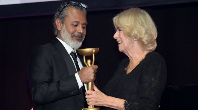 Queen Consort Camilla presents Shehan Karunatilaka with the trophy for the Booker Prize, in London. (Reuters)