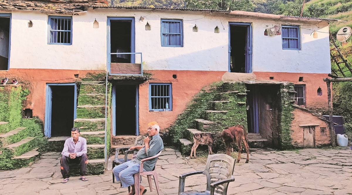 Ankita’s father (sitting on the steps) with her uncle at their ancestral home in Pauri Garhwal. (Express Photo by Avaneesh Mishra)
