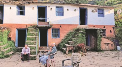 Ankita’s father (sitting on the steps) with her uncle at their ancestral home in Pauri Garhwal. (Express Photo by Avaneesh Mishra)