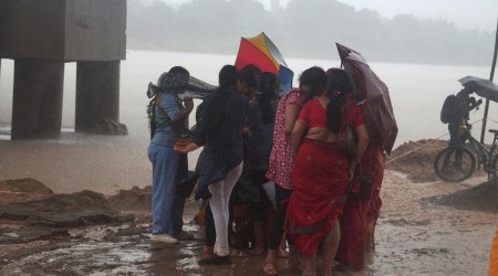 Devotees protect themselves under a flyover as it rains heavily during a Durga idol immersion, in Bhubaneswar (PTI photo)