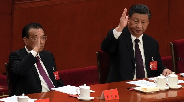 Chinese Premier Li Keqiang, left, and President Xi Jinping raise their hands to vote at the closing ceremony of the 20th National Congress of China's ruling Communist Party at the Great Hall of the People in Beijing, Saturday, Oct. 22, 2022. (AP Photo)