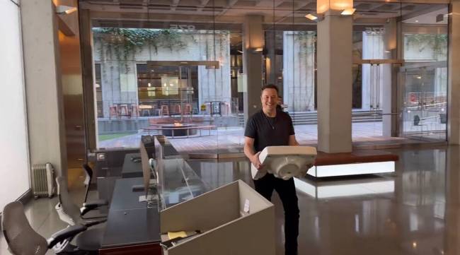 Elon Musk enters the Twitter headquarters holding a sink.