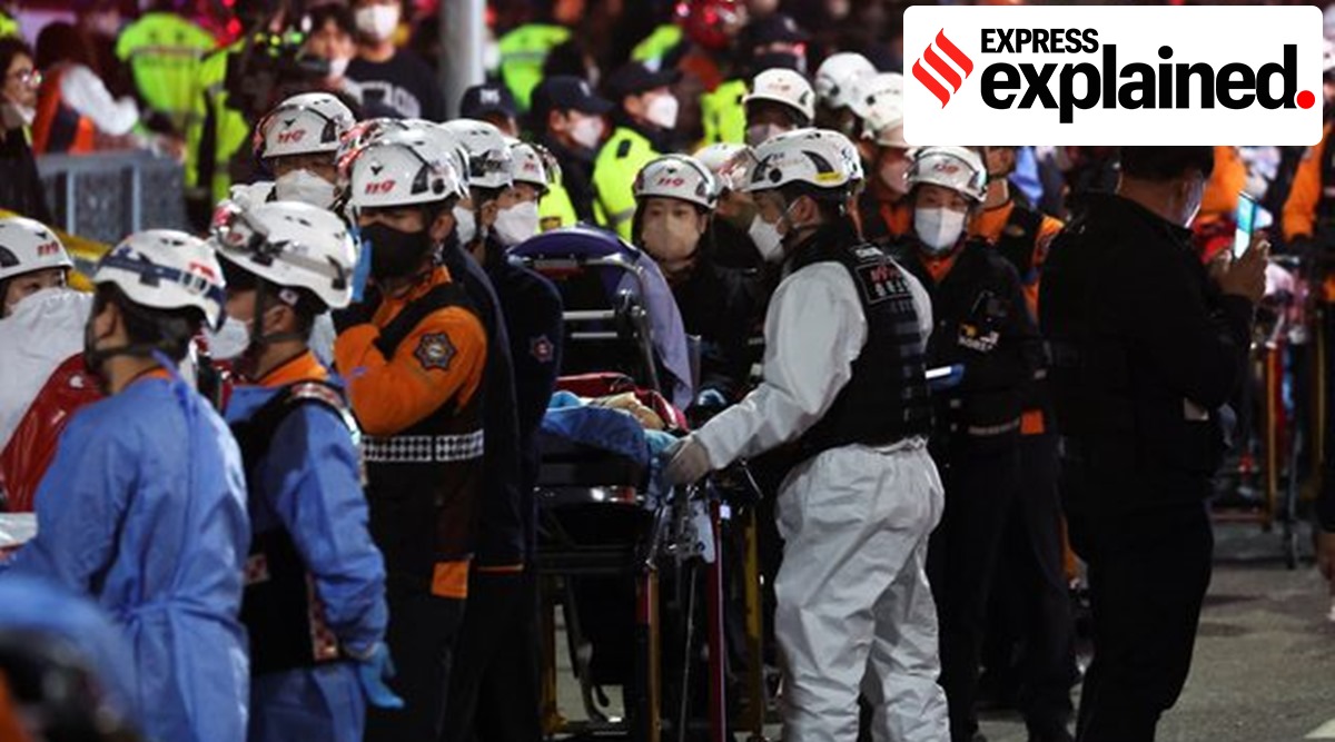 Rescue workers wait with stretchers to move bodies, at the scene where many people died and were injured in a stampede during a Halloween festival in Seoul, South Korea (Reuters)