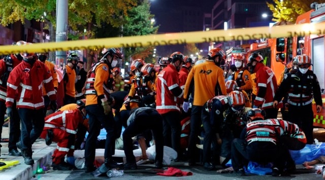 Rescue workers and firefighters work on the scene of a crushing accident in Seoul, South Korea, Saturday, Oct. 29, 2022. (Lee Ji-eun/Yonhap via AP)