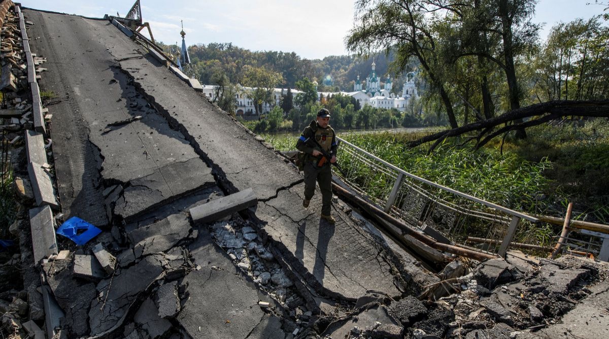 A service member of Ukraine's National Guard walks on a bridge over the Siverskyi Donets river destroyed during Russia's attack on Ukraine, in the town of Sviatohirsk, Donetsk region, Ukraine. (REUTERS/Vladyslav Musiienko)