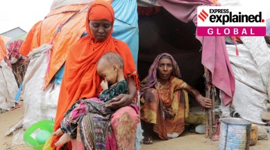 Buney Aayow Ibrahim, a Somali woman affected by the worsening drought due to failed rain seasons, holds her child Sadia Salas Abdi, 3, as her grandmother Habiba Osman looks on, outside their makeshift shelter at the Alla Futo camp for internall