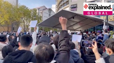 A man's first raised up in the air as part of protest against COVID-19 curbs at Tsinghua University in Beijing.