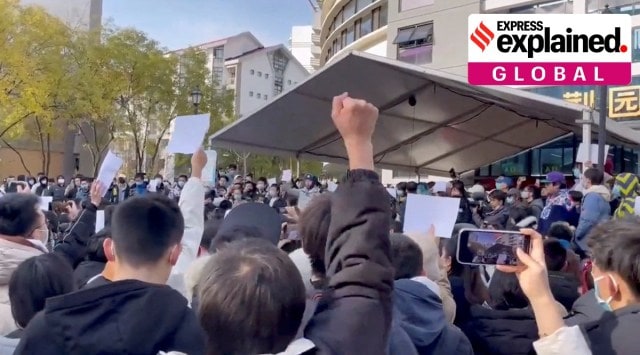 A man's first raised up in the air as part of protest against COVID-19 curbs at Tsinghua University in Beijing.