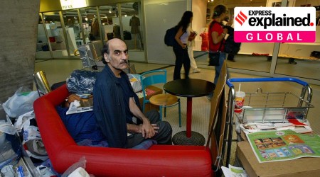 Merhan Karimi Nasseri at the Charles de Gaulle airport in France, sitting on a seat with his belongings.