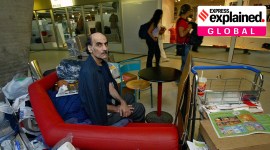 Merhan Karimi Nasseri at the Charles de Gaulle airport in France, sitting on a seat with his belongings.