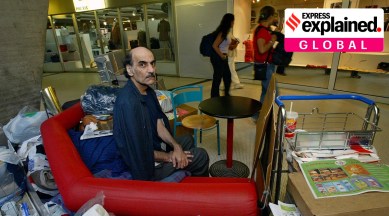 Merhan Karimi Nasseri at the Charles de Gaulle airport in France, sitting on a seat with his belongings.