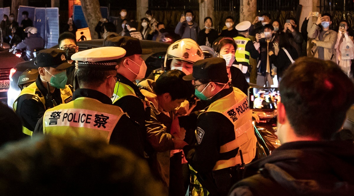 Police officers detain a man in Shanghai, China, on Sunday night, Nov. 27, 2022. In a country where protests are swiftly quashed, many who gathered to voice their discontent over COVID lock-down rules under the watchful eye of the police were uncertain about how far to go (Photo: The New York Times)