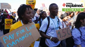Vanessa Nakate, of Uganda, left, participates in a Fridays for Future protest at the COP27 U.N. Climate Summit while holding a sign that says "pay for loss and damage".
