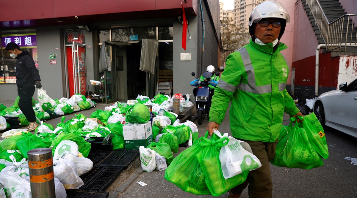 A delivery worker picks up goods at a logistics station of online grocery platform by Meituan, following the coronavirus disease (COVID-19) outbreak in Beijing, China November 23, 2022. (REUTERS/File)
