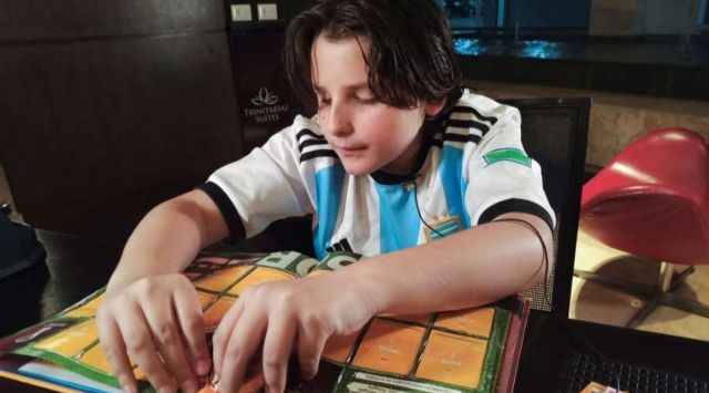 Sebastian Filoramo, 12, a visually impaired boy who adapted the FIFA World Cup Qatar 2022 Panini card album to Braille, checks his album in Barquisimeto, Venezuela. (Reuters) 