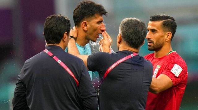 Iran's goalkeeper Alireza Beiranvand is attended by team support staff after he was injured during the World Cup group B soccer match between England and Iran at the Khalifa International Stadium in Doha, Qatar, Monday, Nov. 21, 2022. (AP Photo/Alessandra Tarantino)
