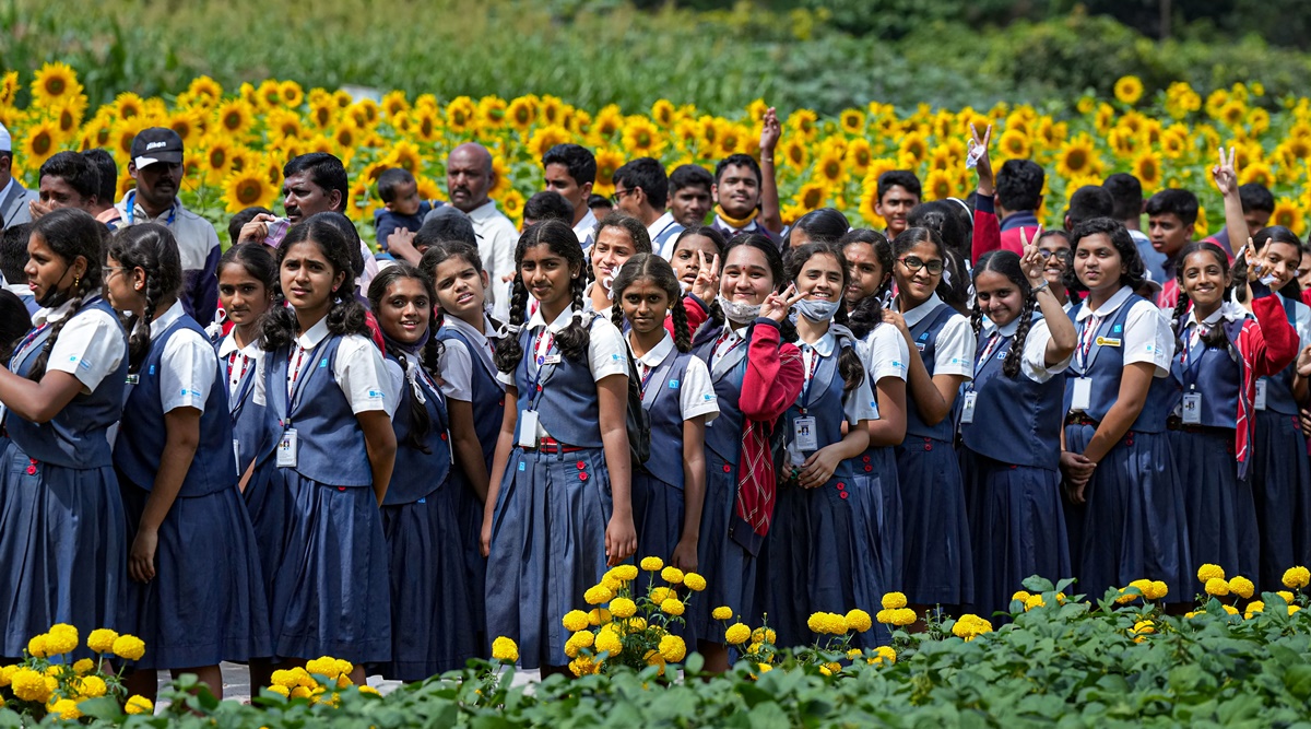 Students walk near sunflowers during the 'Krishi Mela' 2022 organised by University of Agricultural Sciences, at Gandhi Krishi Vigyana Kendra (GKVK) in Bengaluru, Thursday, Nov. 3, 2022. Karnataka education minister has asked schools to hold 10-minutes of meditation session daily. (PTI Photo)
